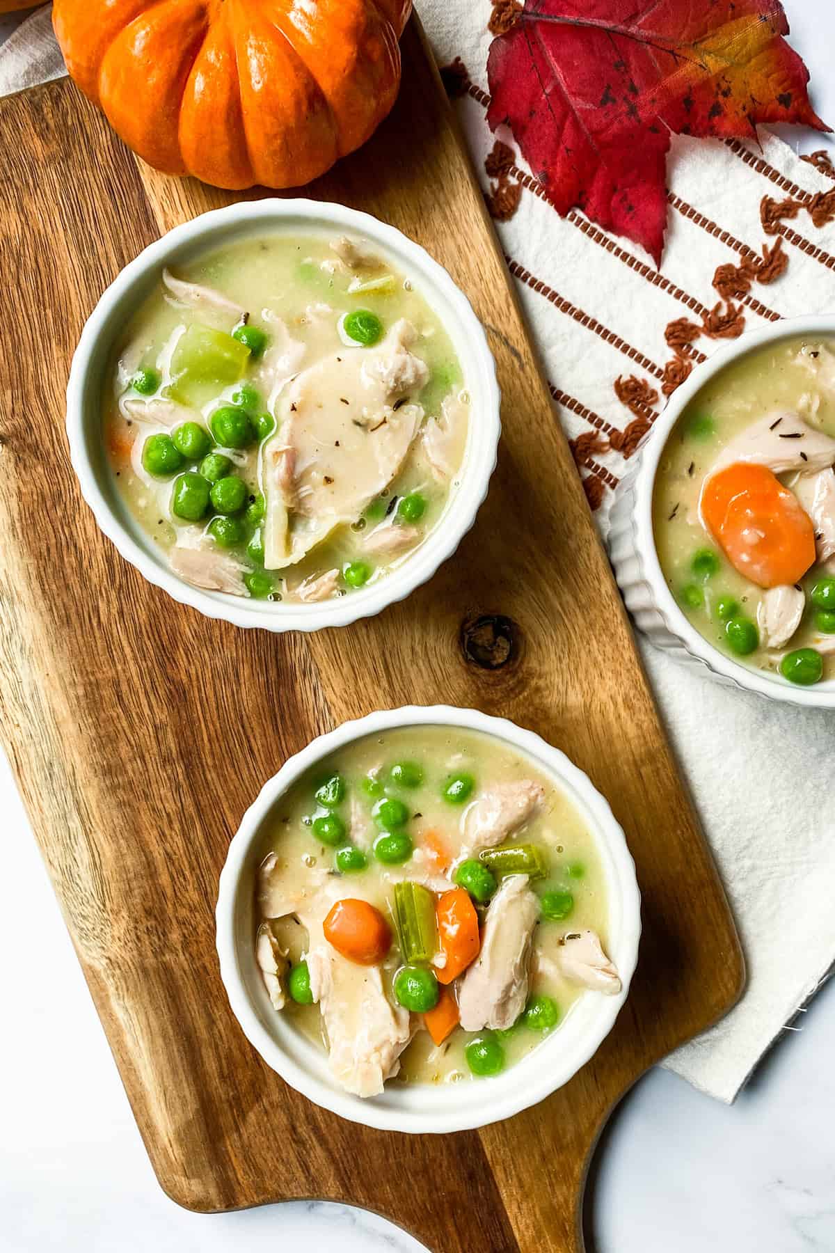 Unbaked filling for mini chicken pot pies in white ramekins.