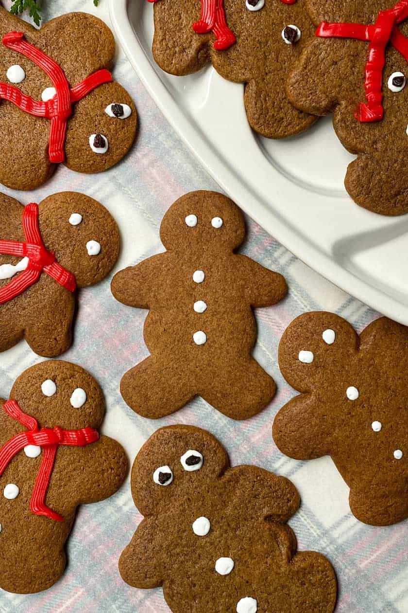 Gingerbread Cookie Shapes decorated with frosting eyes, buttons and read scarves.
