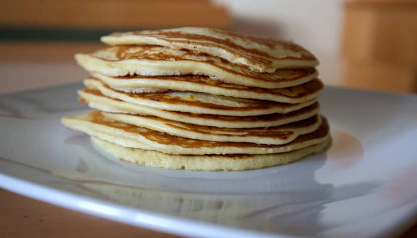 Stack of protein pancakes on a white plate