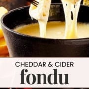 Two pieces of bread are dipped into a pot of rich cheddar fondue, with gooey cheese stretching between the bread and the pot.