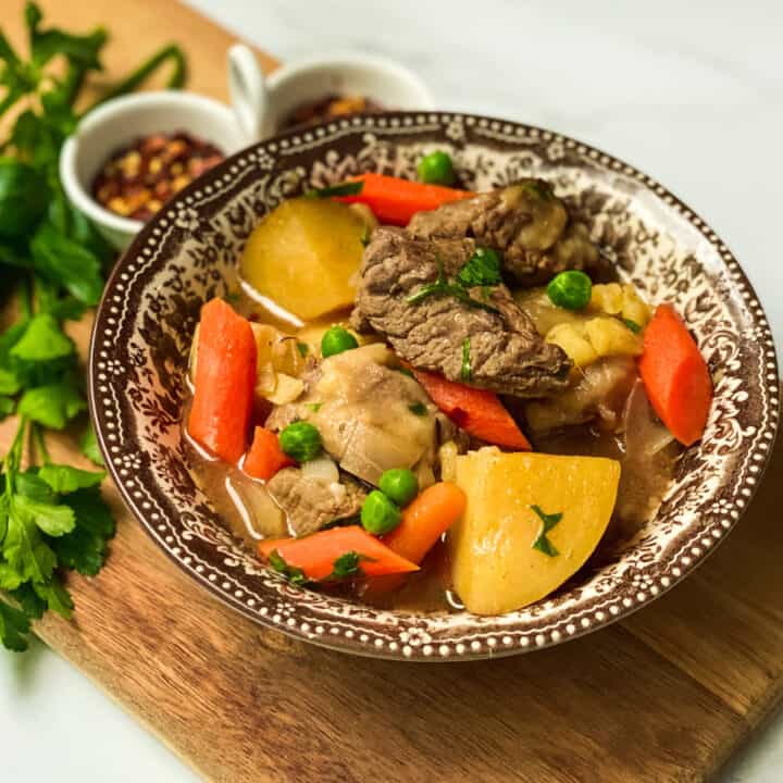 Brown and White Bowl of Slow Cooker Beef Stew with Potatoes, Carrots and Peas