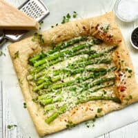 Top view of Asparagus Tart with a block of Parmesan cheese