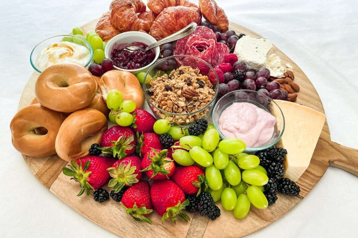 Brunch Charcuterie Board with fruit, bagels, croissants, fruit, and cheese