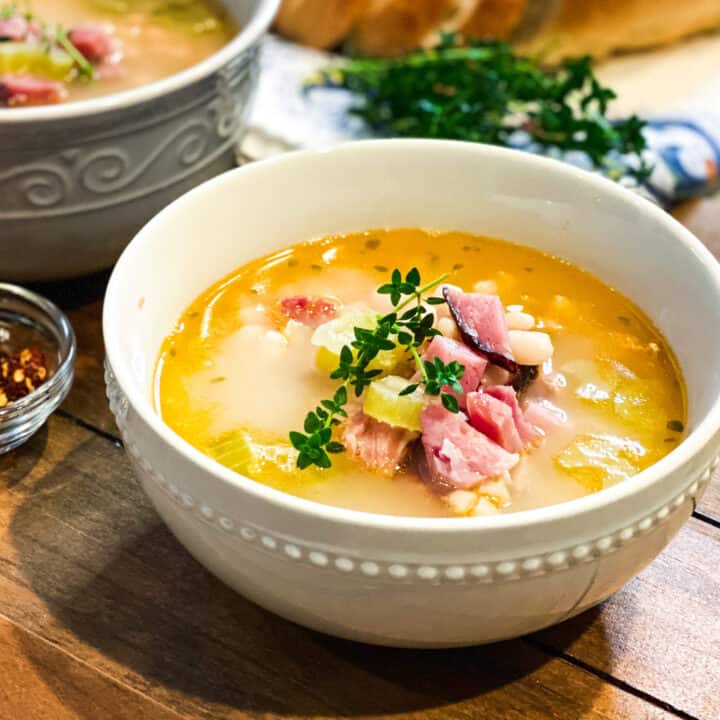 Ham Bone Soup in a White Bowl with Ham and Fresh Thyme