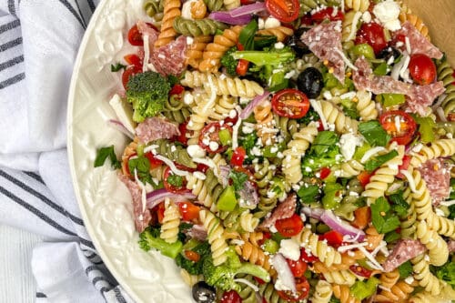 Top view of Pasta Salad in a white bowl with a blue striped linen.