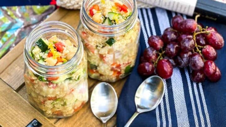 Quinoa Salad in mason jars with grapes and a picnic basket