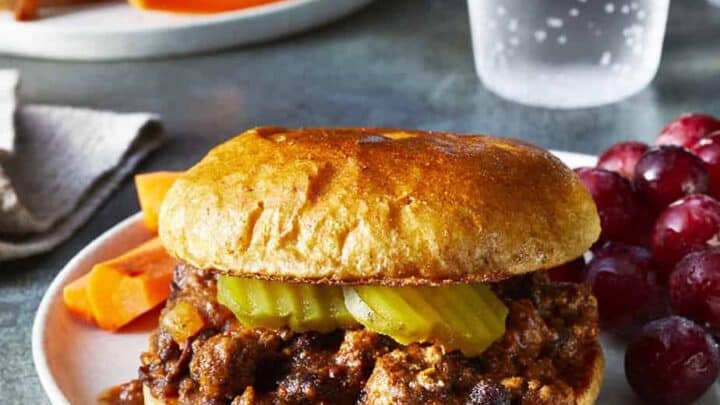 Sloppy Joe on a bun with pickles and grapes