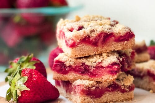 Stacked Strawberry Crumble squares stacked with fresh strawberries