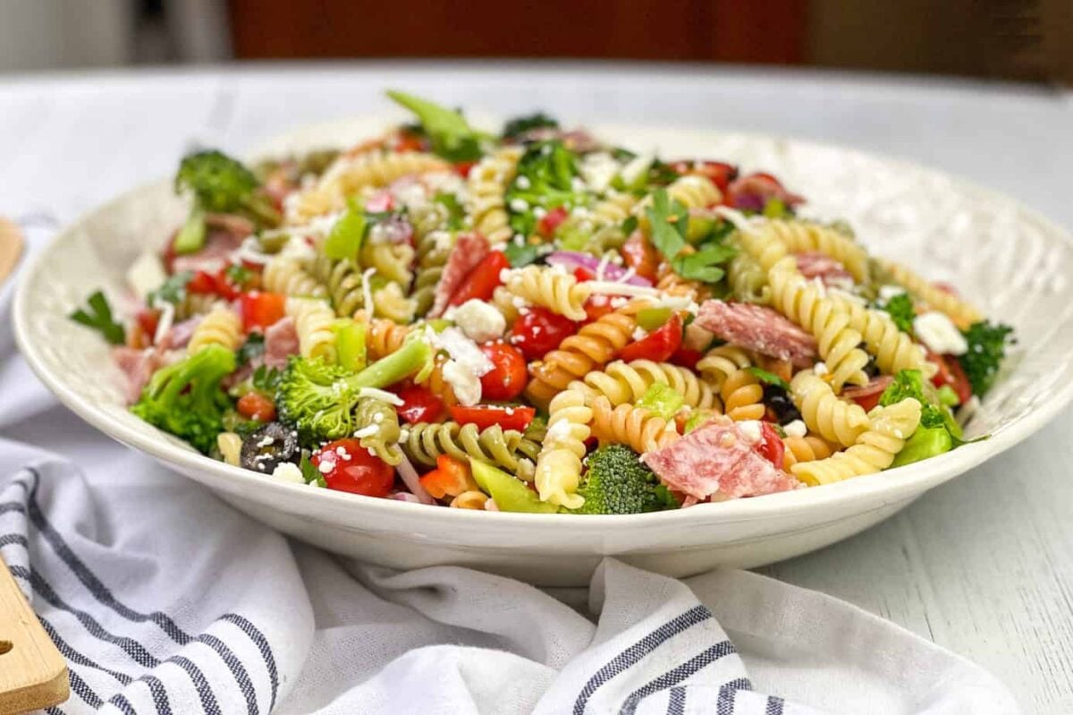 Pasta Salad in a White Bowl with salami and vegetables.