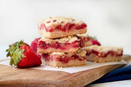 Stacked Easy Strawberry Crumble Bars on a wooden board