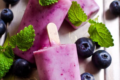 Vertical view of Blueberry Popsicles on a Wooden Tray