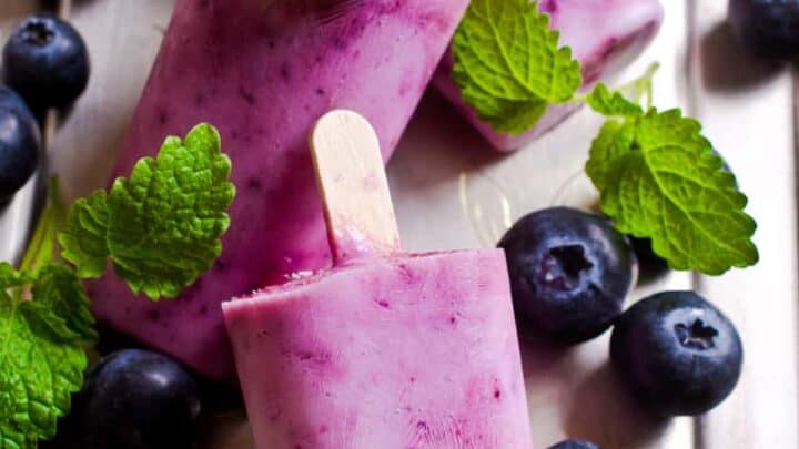 Vertical view of Blueberry Popsicles on a Wooden Tray