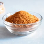 A small glass bowl filled with a dry rub recipe for grilling in a glass container.