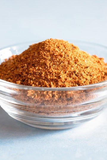 A small glass bowl filled with a dry rub recipe for grilling in a glass container.