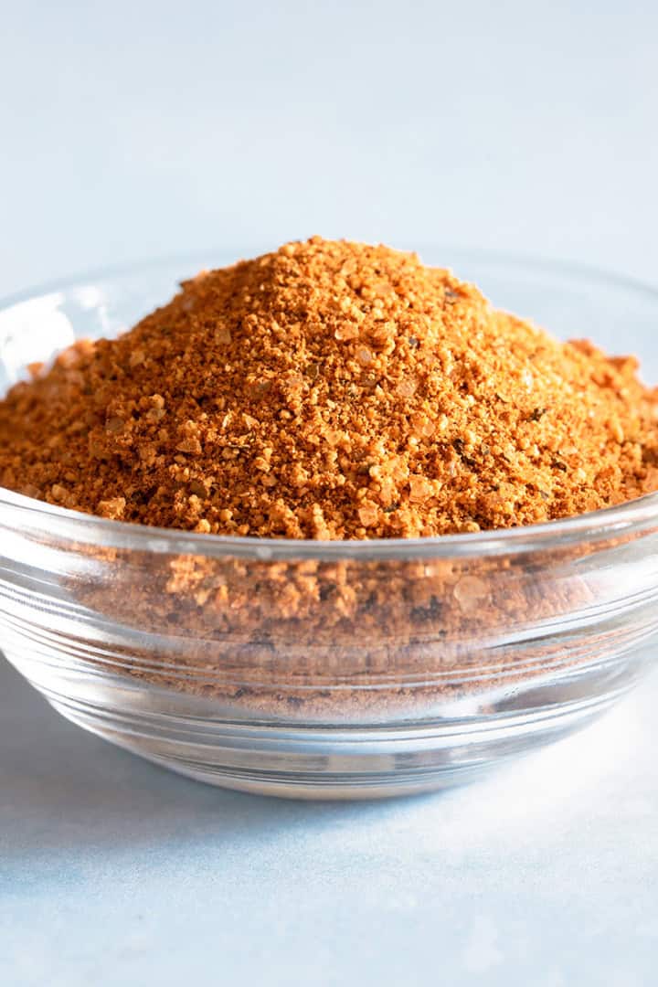 A small glass bowl filled with a dry rub recipe for grilling in a glass container.