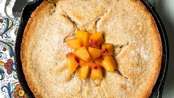 Skillet Peach Cobbler garnished with fresh chopped peaches