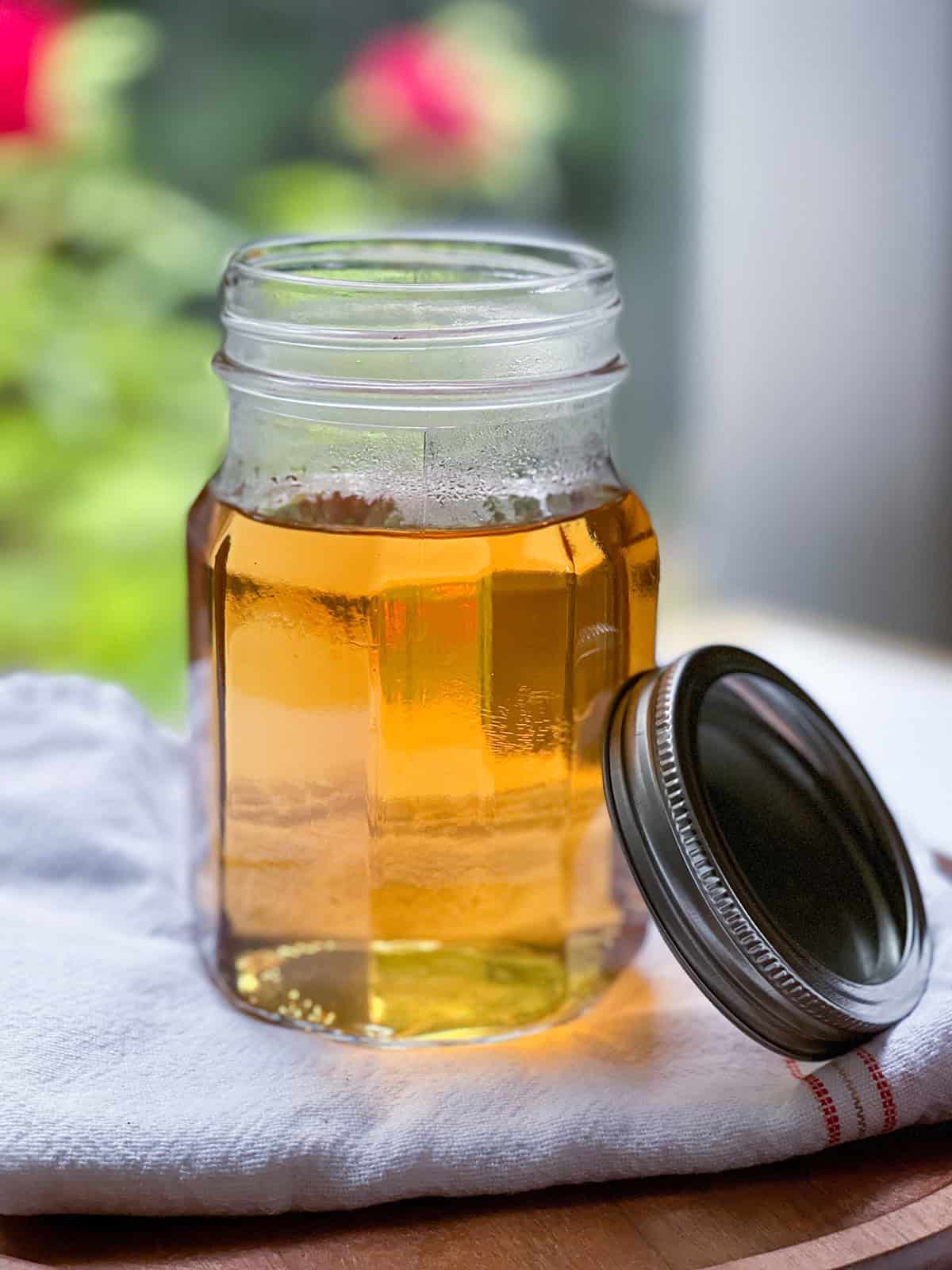 A glass jar filled with vanilla syrup for an iced vanilla latte.