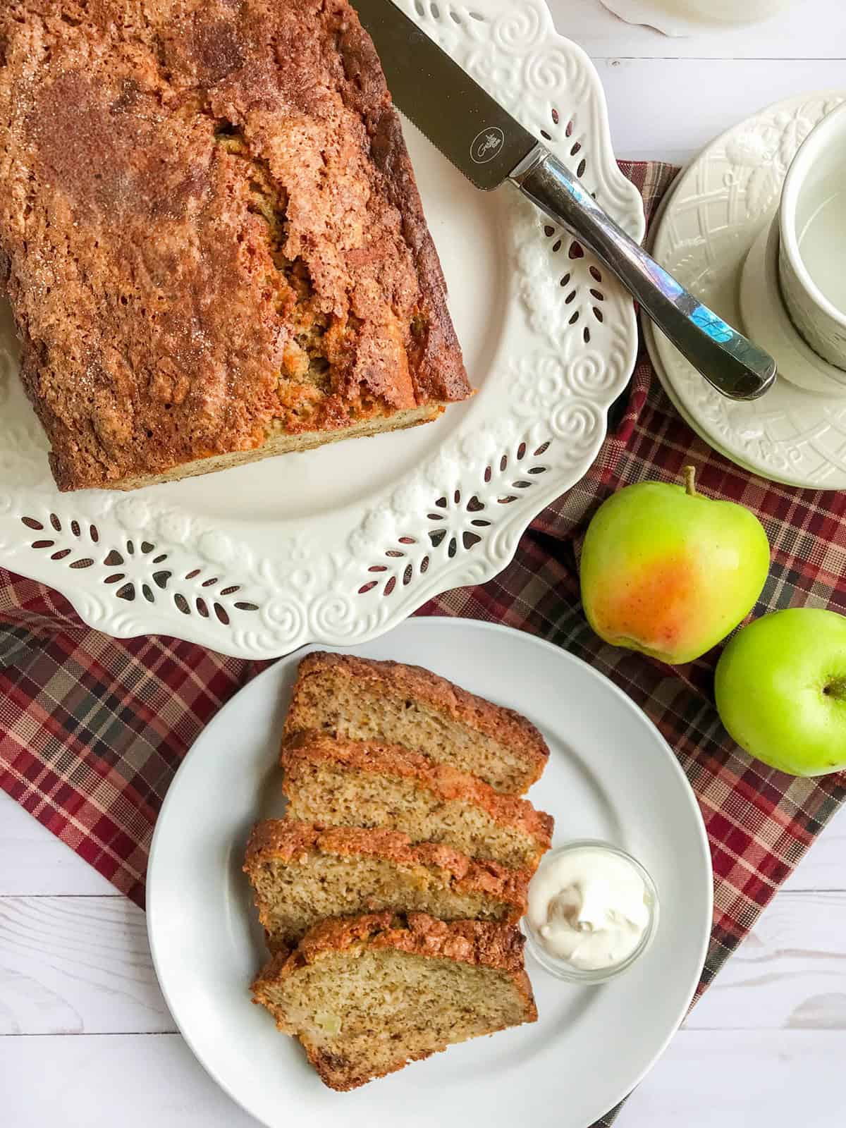 Sliced apple banana bread with softened butter on the side of serving.