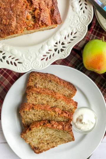 Sliced loaf of apple banana bread with creamy butter for serving.