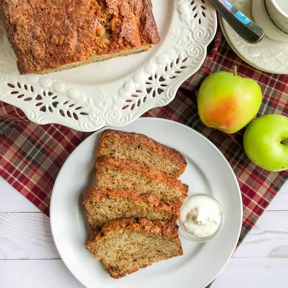 Sliced loaf of apple banana bread with creamy butter for serving.