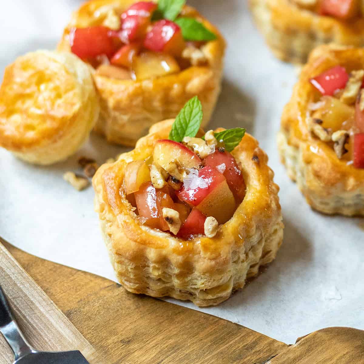 Closeup view of mini apple tart with apple pie filling and mint sprigs.
