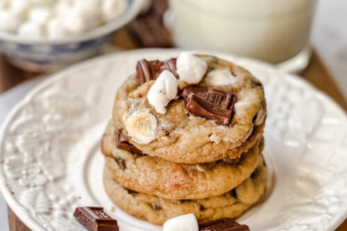 Closeup side view of S'mores Cookies stacked on a white plate