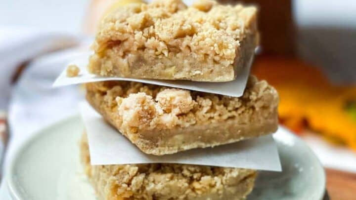 Stacked Apple Pie Bars with fresh apples in the background
