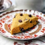 A chocolate chip pumpkin scone on a serving plate ready for tea.
