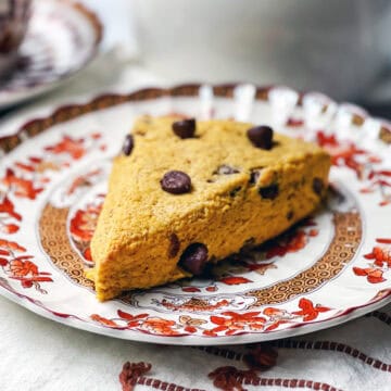 A chocolate chip pumpkin scone on a serving plate ready for tea.