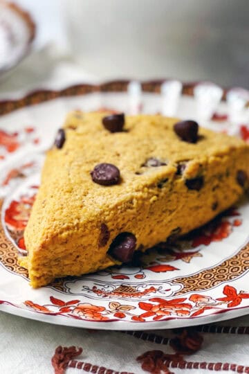 A chocolate chip pumpkin scone on a serving plate ready for tea.