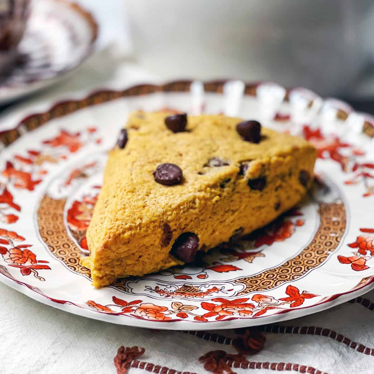 A chocolate chip pumpkin scone on a serving plate ready for tea.