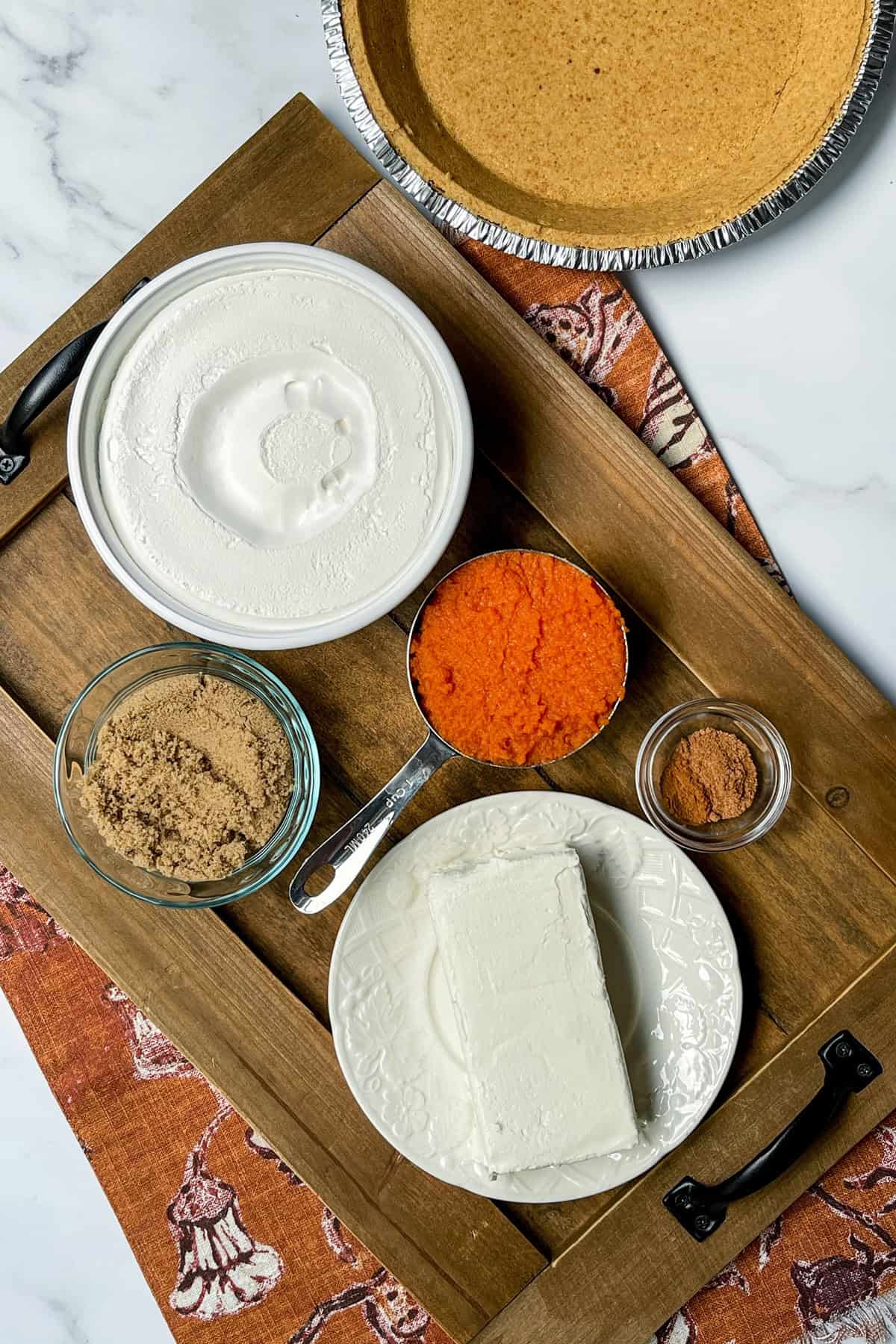 Ingredients for no bake pumpkin cheesecake including cream cheese and pumpkin.