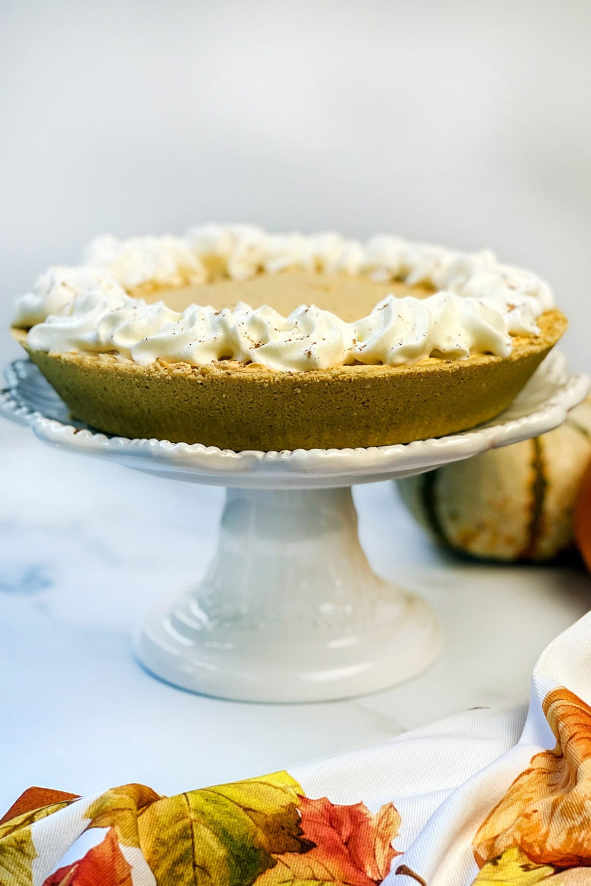 Whole no bake pumpkin cheesecake on a serving stand.