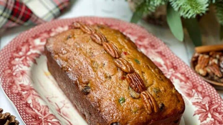 Side view of glazed Christmas Cake with evergreens in the background