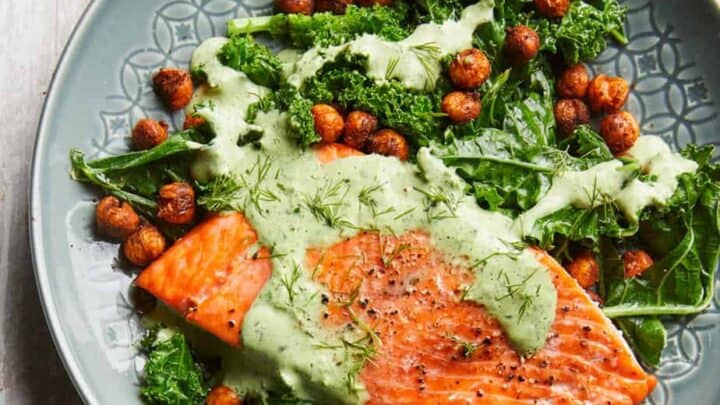 A plate with baked salmon, kale, roasted chickpeas, and green herb sauce—perfect for healthy January DASH Diet Dinners.
