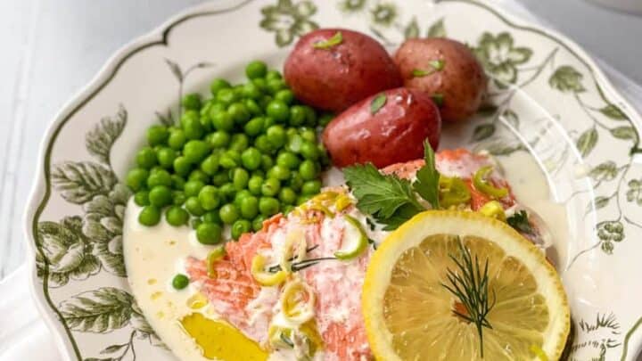 Irish Baked Salmon and Cream Sauce on a plate with peas and steamed red potatoes