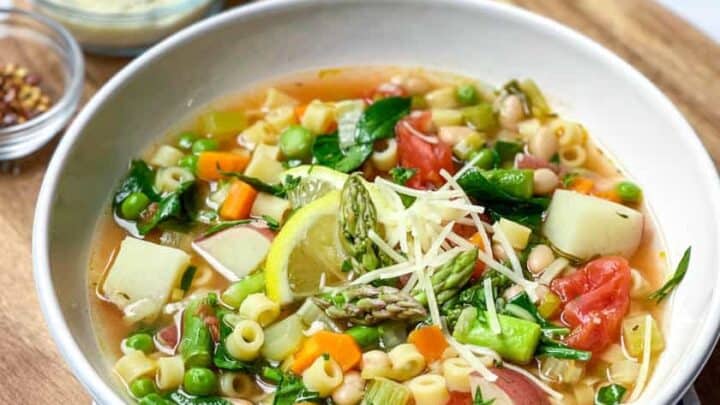 Bowl of Spring Minestrone Soup with Parmesan and Italian bread slices