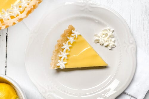 Top view of Lemon Curd Tart slice with sweetened whipping cream