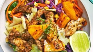 A bowl of grilled chicken, pineapple, mixed greens, shredded cabbage, corn, and a lime wedge—perfect for Healthy 5 Ingredient Spring Dinners.