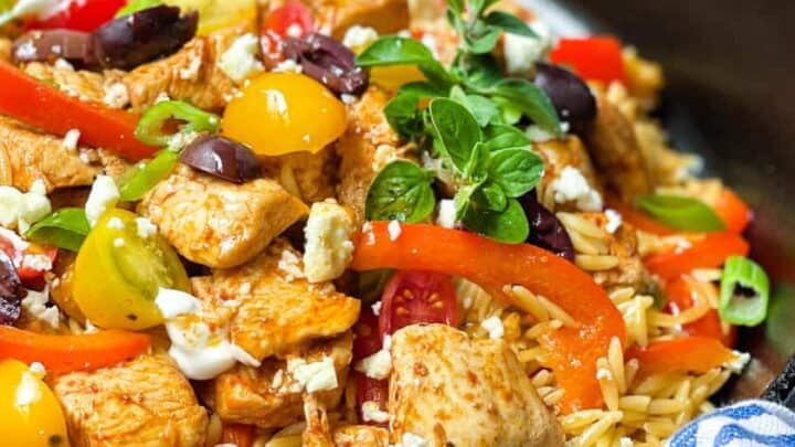 Closeup view of Greek Chicken and Orzo Skillet in a black cast iron skillet