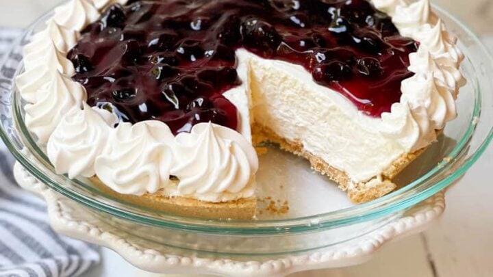 Whole No Bake Cheesecake with a slice missing on a cake stand