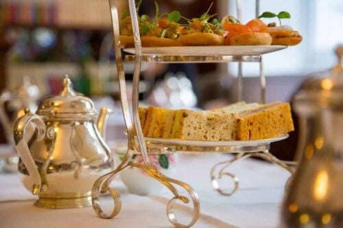Closeup view of 3 tier stand for afternoon tea with tea sandwiches and savory recipes