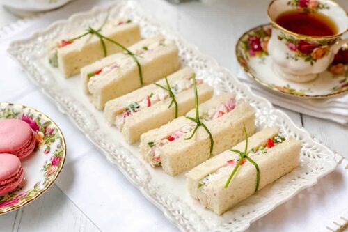Side view of Strawberry Chicken Salad Tea Sandwiches on a white platter