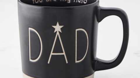 Black ceramic mug with "DAD" on the front and "You are my hero" inside the rim, placed on a white surface—an ideal choice for Father's Day Gifts.