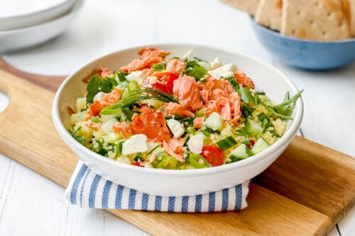 Side view of Mediterranean Couscous Salad with Smoked Salmon in a white pasta bowl