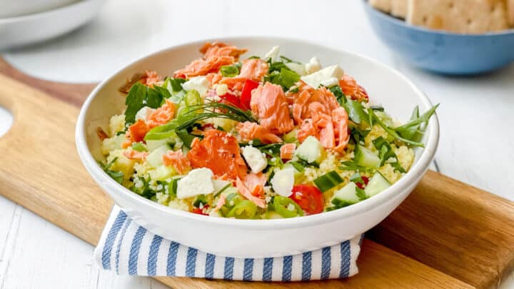Side view of Mediterranean Couscous Salad with Smoked Salmon in a white pasta bowl