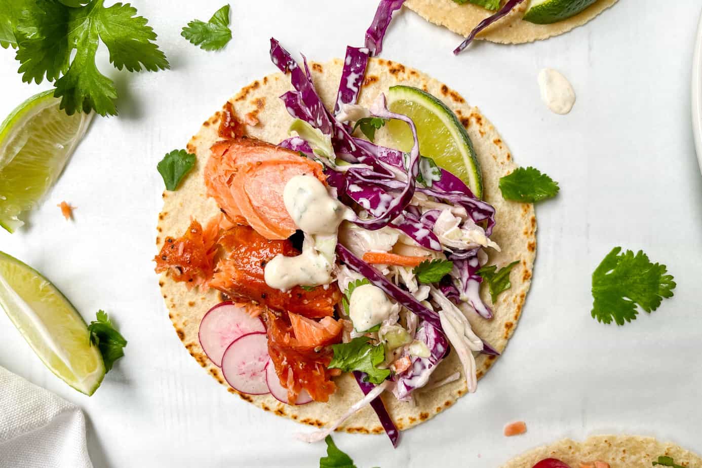 Top view of 10 Minute No Cook Salmon Tacos with cilantro and lime wedges