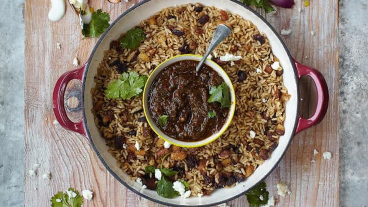 Overhead view of a wooden board with grilled chicken and vegetables, a pot of rice and beans with sauce, tortillas, lime wedges, and fresh cilantro—perfect for quick 15 Minute Summer Dinners.