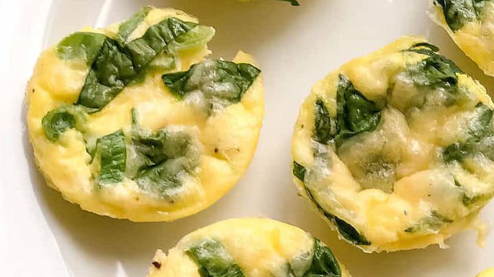 Closeup view of Egg Bites with spinach on a white plate
