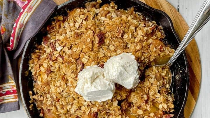 Top view of Skillet Peach Crisp with vanilla ice cream scoops